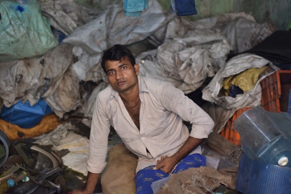 Surrounded by plastics, a man takes a short break from work. Photo: Suhas Paunikar. 