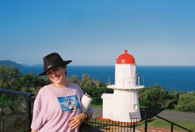 A woman standing in front of the Cooktown Lighthouse.